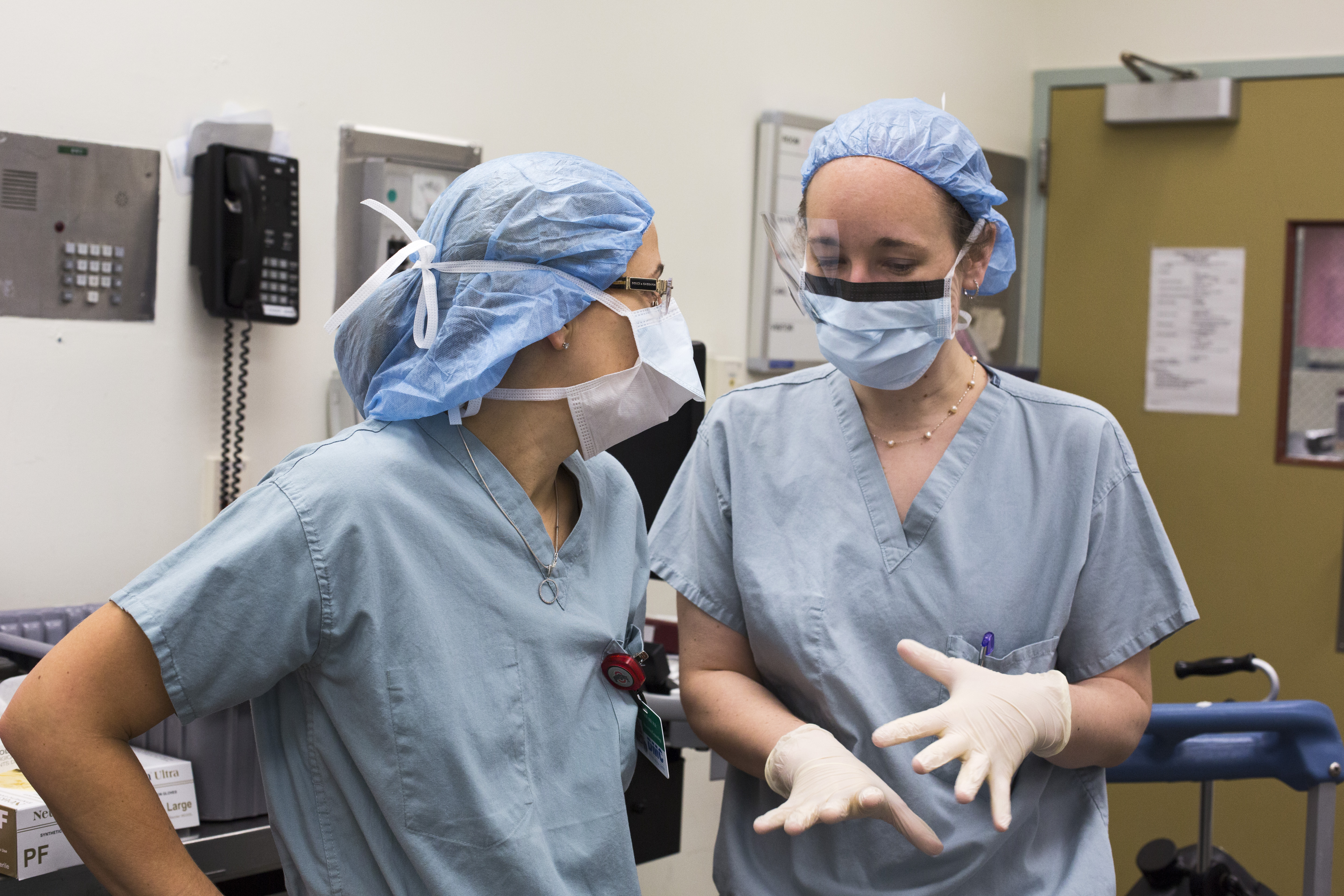 Hospital workers talk in an operating room